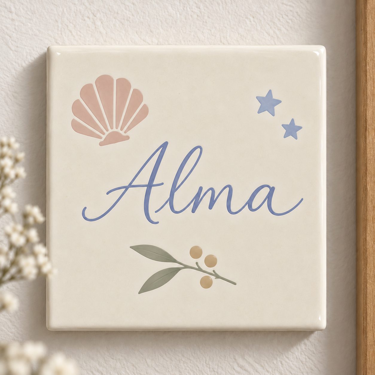 Carreau souvenir au prénom « Alma », calligraphie bleue, coquillage rose, deux étoiles et rameau à baies dorées, peint et émaillé à la main