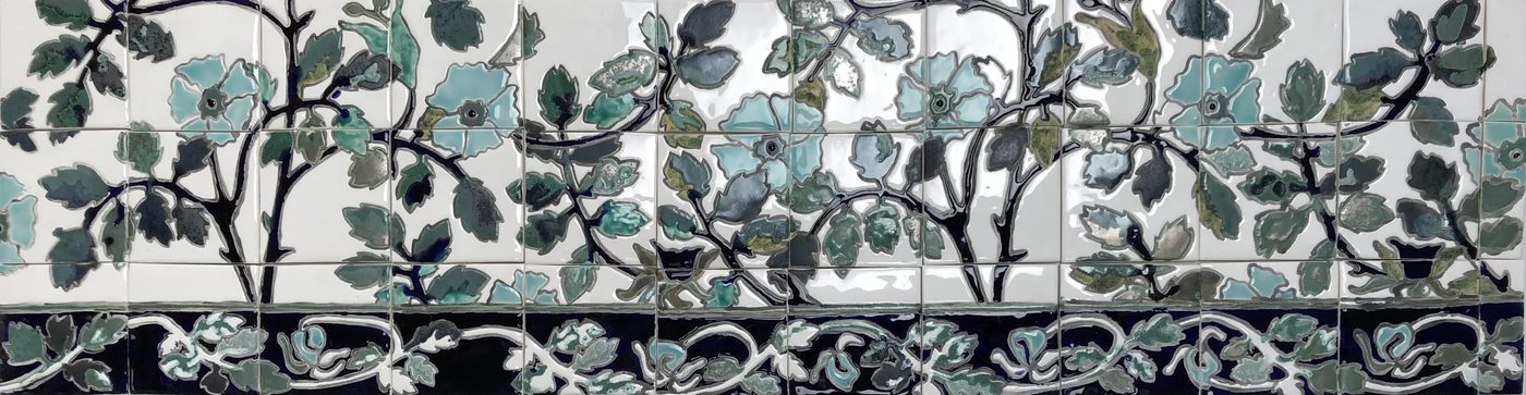 Crédence en céramique autour d’un lavabo d’atelier, branches de pivoines bleu-gris et bordure de rinceaux sombre